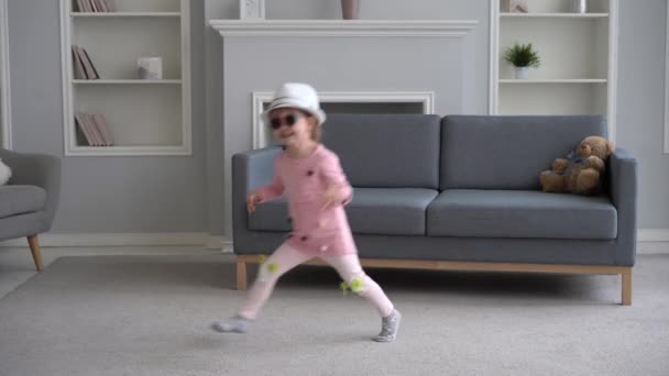 Flicka hoppa ha kul i vardagsrummet, aktiv glad flicka dans hemma njuta av fritidsaktivitet tillsammans — Stockvideo