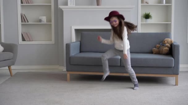 Meisje springen plezier hebben in de woonkamer, actief vrolijk meisje dansen thuis genieten van vrijetijdsbesteding samen — Stockvideo