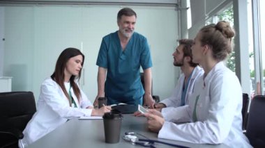 Bir grup doktor tıbbi konferansta röntgene bakıyor, sorunları tartışıyorlar.