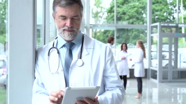 Dokter menggunakan tablet digital di koridor rumah sakit. — Stok Video