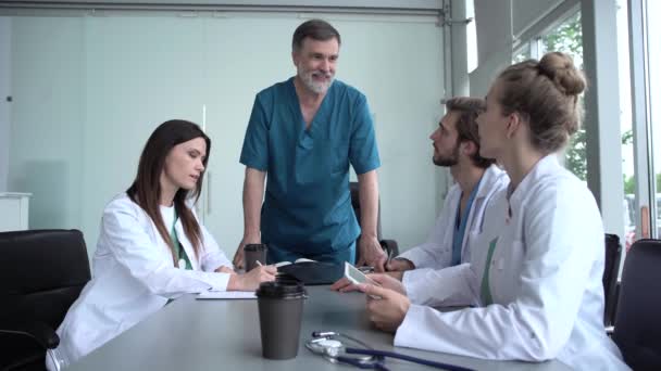 Groep artsen die röntgenfoto 's van medische conferentie bekijken, discussiëren over kwesties — Stockvideo
