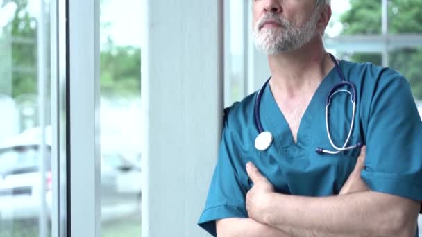 Selbstbewusst nachdenkliche Senior erwachsene männliche Berufsmediziner, trägt alten Arzt weißen Arztkittel, Blick durch Fenster träumend, denkend. Gesundheits- und Medizinkonzept — Stockvideo