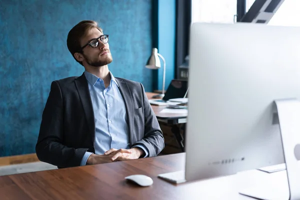 열심 히 일 한 후 안경과 푸른 셔츠를 입고 사무실에서 편안히 쉬고 있는 행복 한 사업가의 모습. — 스톡 사진