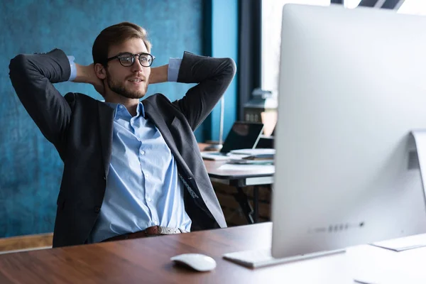 Homme d'affaires souriant heureux dans des lunettes et chemise bleue relaxant au bureau après une dure journée de travail. — Photo