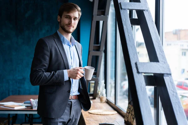 Glad attraktiv ung affärsman dricka kaffe på kontoret. — Stockfoto