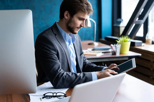 Glimlachende man op kantoor aan het werk op digitale tablet. — Stockfoto