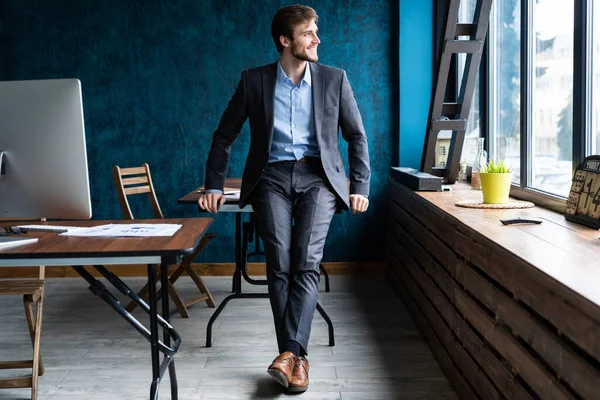 Empresario con traje moderno y puestos en la oficina contemporánea . — Foto de Stock