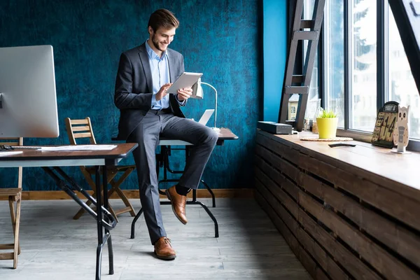 Knappe, elegante zakenman die aan een tablet werkt. — Stockfoto