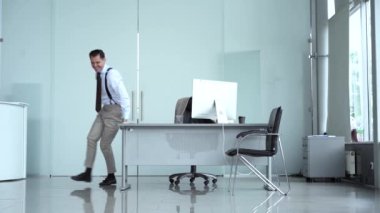 Heyecanlı genç çalışan yönetici girişimci iş başarısını, terfiyi, profesyonel başarıyı ya da ödülü modern ofiste dans etmeyi kutluyor..