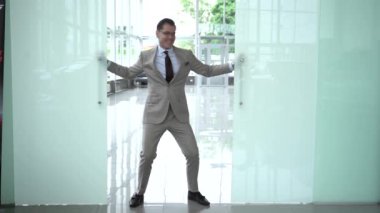 Heyecanlı genç çalışan yönetici girişimci iş başarısını, terfiyi, profesyonel başarıyı ya da ödülü modern ofiste dans etmeyi kutluyor..