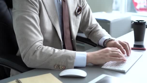 Sonriente joven empresario escribiendo en el teclado de la computadora y mirando el monitor de la computadora . — Vídeo de stock