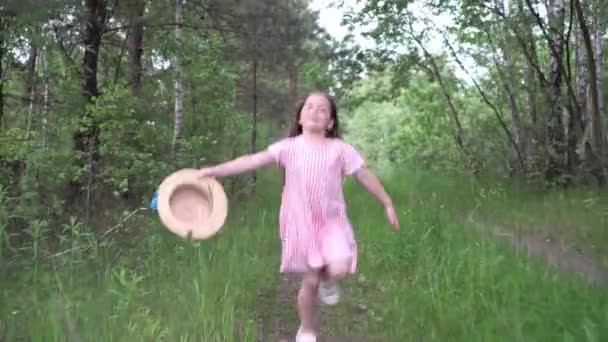 Gadis gembira berjalan melalui hutan musim semi. — Stok Video
