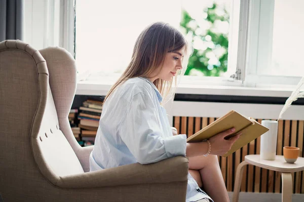 Schöne Mädchen beim Lesen eines Buches zu Hause. Freizeit in Innenräumen — Stockfoto