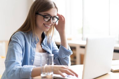 Evde çalışmak bana esnek çalışma olanağı sağlıyor. Memnuniyet verici genç kadın evde bilgisayar çalışıyor..