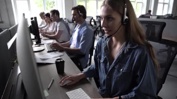 Agent vrouw in headset gebruik pc antwoorden inkomende gesprekken gesprek met de klant bieden professionele ondersteuning aan klanten — Stockvideo