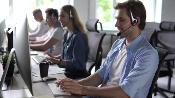 헤드셋에 초점을 맞춘 남성 대표 콜 센터 에이전트 사무실에서 컴퓨터를 사용하는 불만으로 고객을 돕는 모습 — 비디오