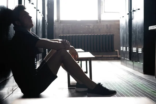 Genç atletik beyaz adam, spor yaptıktan sonra soyunma odasında yalnız başına dinleniyor.. — Stok fotoğraf
