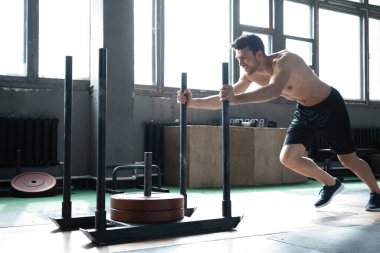 Spor salonunda egzersiz yapan formda bir erkek sporcu..