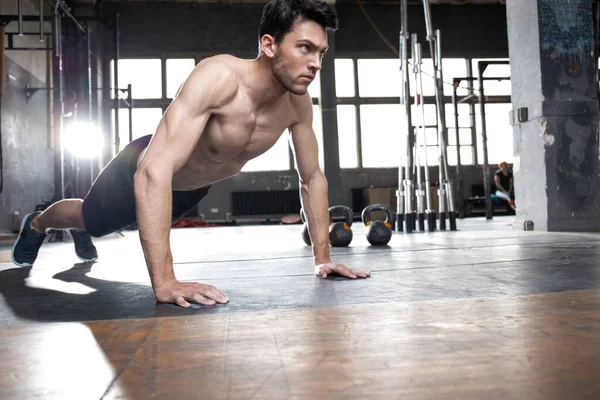 Ein muskulöser Mann macht Liegestütze im Crossfit-Fitnessstudio. — Stockfoto