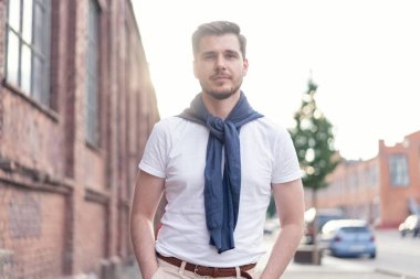 Şehirde yürüyüş yapan yakışıklı bir genç adam. Neşeli genç adam şehri geziyor..