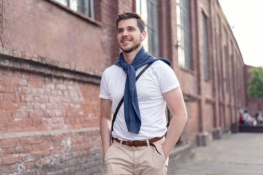 Şehirde yürüyüş yapan yakışıklı bir genç adam. Neşeli genç adam şehri geziyor..