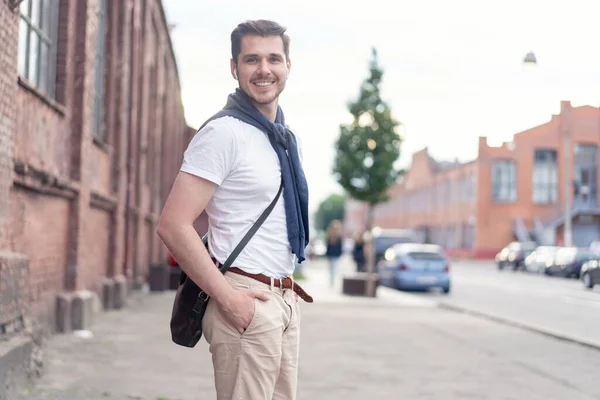 Beau jeune homme en promenade en ville. Joyeux jeune homme profitant de marcher dans la ville. — Photo
