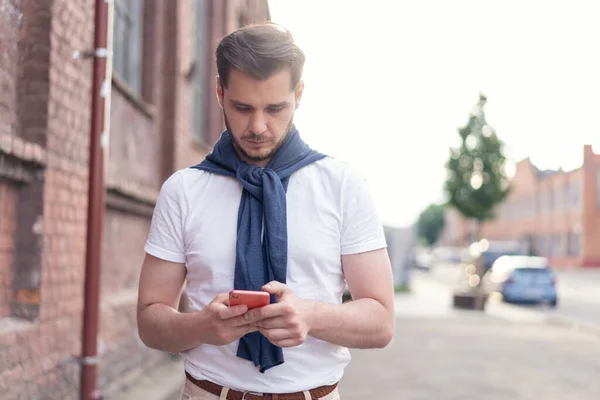 Homem moderno hipster bonito usando smartphone na cidade . — Fotografia de Stock