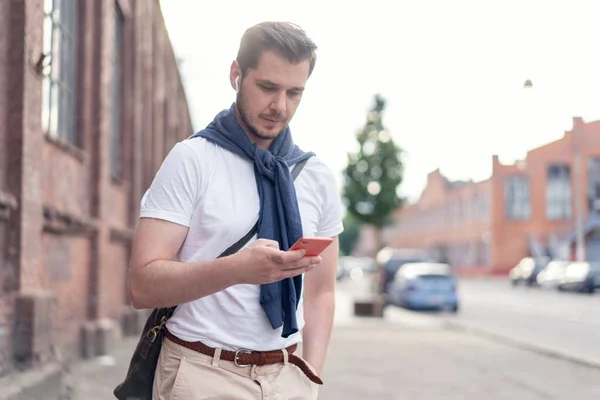 Homem moderno hipster bonito usando smartphone na cidade . — Fotografia de Stock