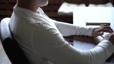 Ofiste çalışan bilgisayar kullanan kıdemli serbest çalışan. Gülümseyen gri saçlı gözlüklü adam bilgisayarda yazı yazıyor.