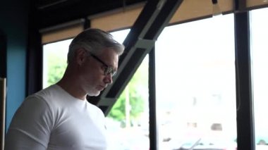 Ofiste çizimlerle çalışan olgun beyaz bir mimar. Profesyonel adam yeni bina geliştirme projesi üzerinde çalışıyor
