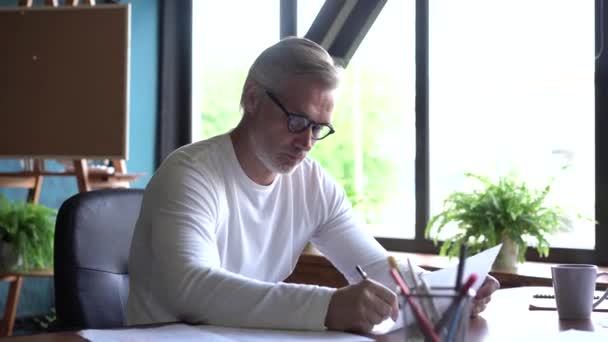 Architecte caucasien mature travaillant avec des dessins au bureau. Homme professionnel travail sur le projet de développement de nouveaux bâtiments — Video