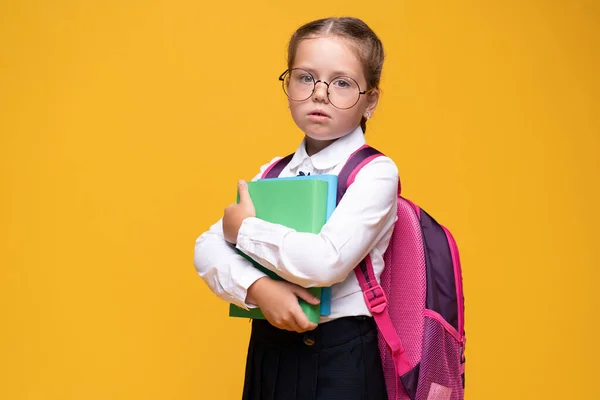 Retrato triste menina de pé sobre um fundo amarelo — Fotografia de Stock