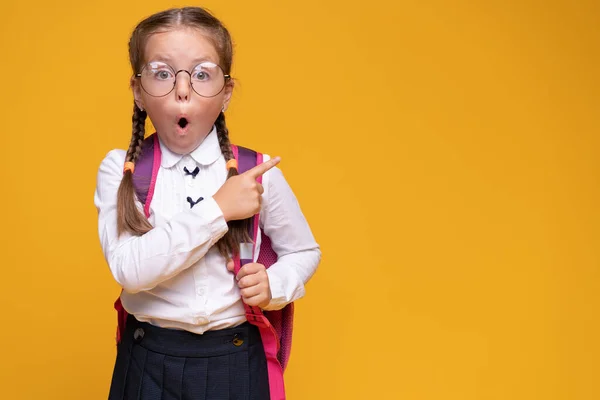 Menina com mochila escolar apontando o dedo para cima, conceito de ideia . — Fotografia de Stock