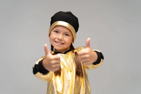 Щаслива маленька дівчинка в золотому костюмі танцює ізольовано на білому тлі . — стокове фото