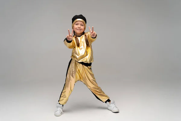 Happy little girl in gold suit dancing isolated on white background. — Stock Photo, Image