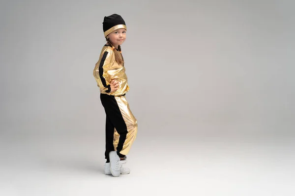 Happy little girl in gold suit dancing isolated on white background. — Stock Photo, Image