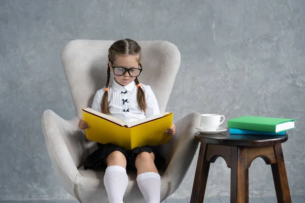School girl focused on reading book sit in armchair. — Stock Photo, Image