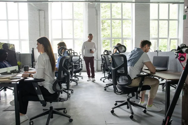 Kontorslivet. Grupp av unga affärsmän som arbetar och kommunicerar tillsammans på kreativa kontor. — Stockfoto