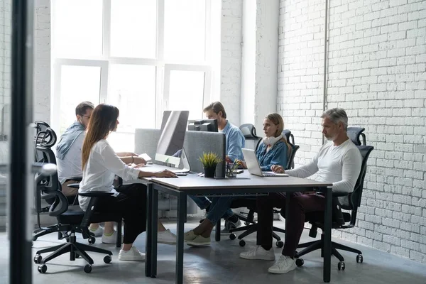 Office life. Group of young business people working and communicating together in creative office.