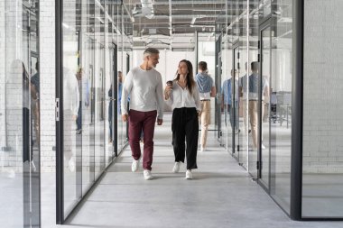 Tam boy modern insanlar ofiste yürürken gündelik kıyafetlerini giyerler.