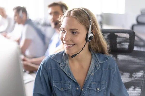 Hoe kan ik u helpen Mooie call center werknemers in hoofdtelefoon werken op modern kantoor — Stockfoto