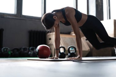 Spor salonunda tahta döşeyen bir kadın. Sağlıklı yaşam tarzı kavramı