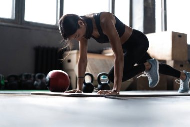Spor salonunda tahta döşeyen bir kadın. Sağlıklı yaşam tarzı kavramı