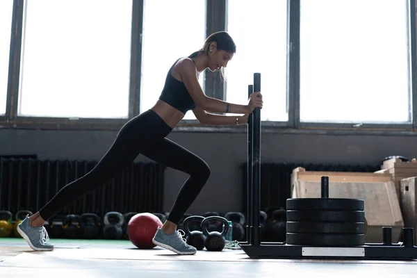 Μια γυμνασμένη αθλήτρια γυμνάζεται στο γυμναστήριο. Crossfit γυναίκα άσκηση — Φωτογραφία Αρχείου
