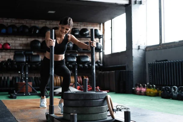 Ajuste atleta femenina haciendo ejercicio en el gimnasio. Crossfit mujer haciendo ejercicio — Foto de Stock