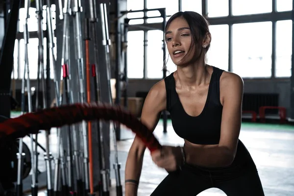 Ισχυρό ελκυστική μυϊκή γυναίκα CrossFit εκπαιδευτή κάνει προπόνηση μάχη με σχοινιά στο γυμναστήριο — Φωτογραφία Αρχείου