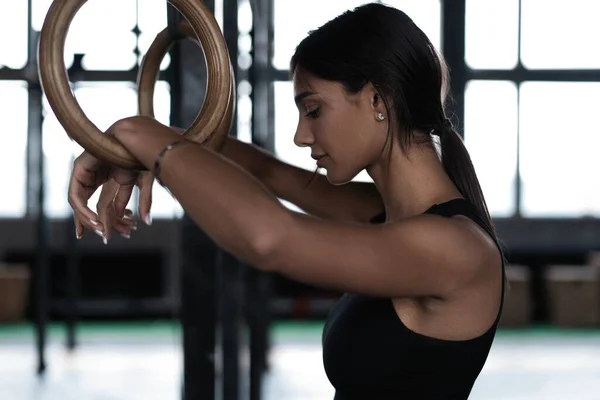 Exercice femme tenant des anneaux de gymnaste et détournant les yeux. Femme prenant du repos après une séance d'entraînement intense au gymnase — Photo