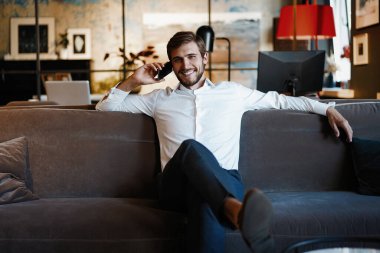 Ofiste oturup konuşan mutlu bir işadamı..