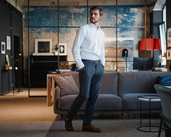 Comprimento total de belo jovem empresário de camisa branca andando pela sala em seu próprio escritório. — Fotografia de Stock