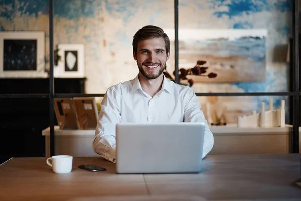 Schöner Geschäftsmann arbeitet im Büro mit Laptop — Stockfoto